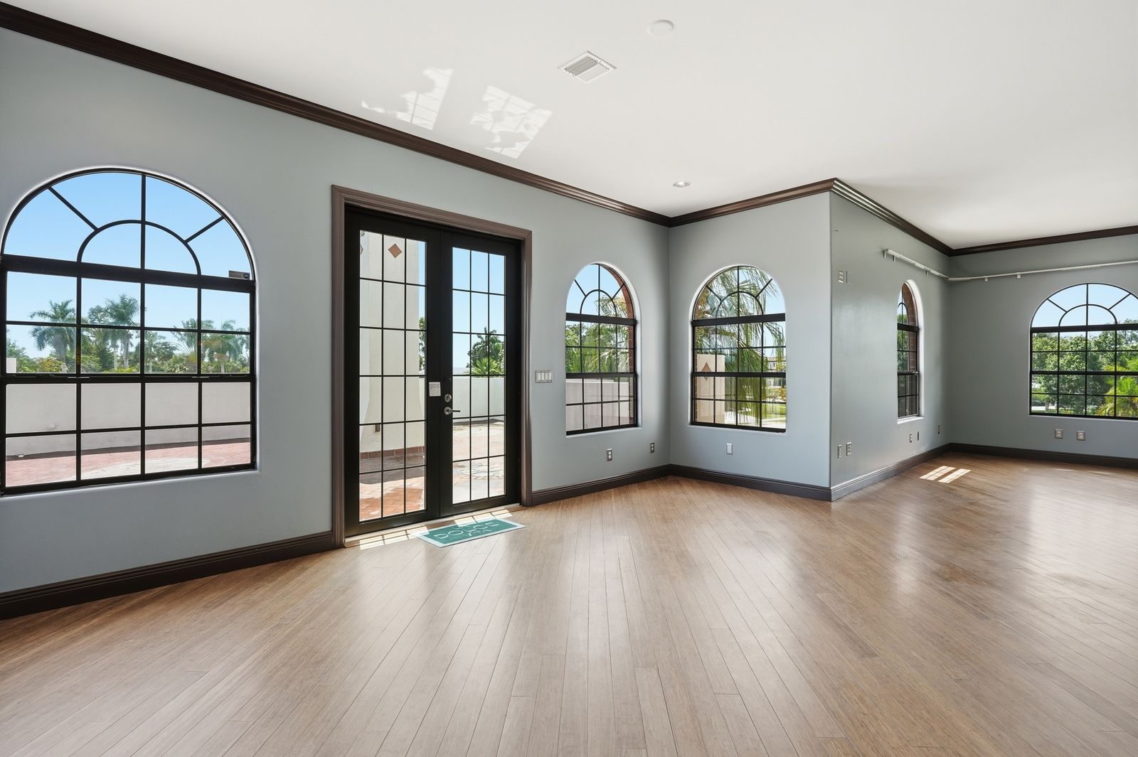 The primary bedroom at 1358 Hopedale Drive, with arched windows and French doors to the terrace