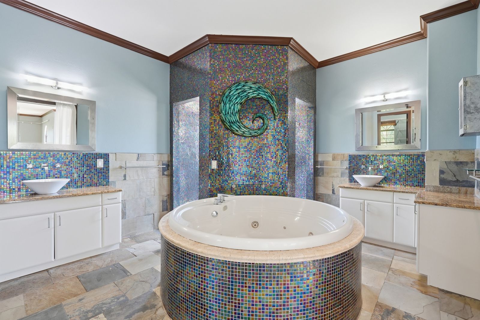 Primary bath with a jetted soaking tub and mosaic tile
